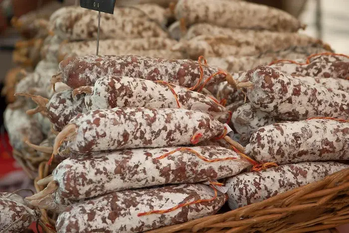de nombreux saucissons en présentation dans un panier d'osier